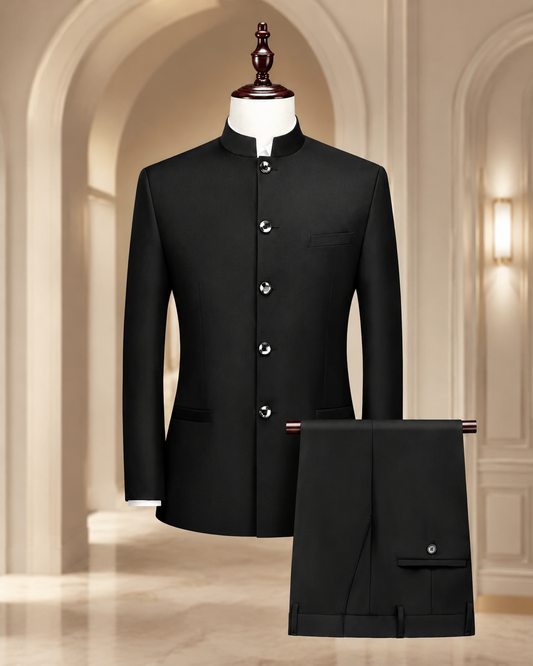 A black traditional Indian formal suit set consisting of a mandarin collar jacket displayed on a mannequin and matching trousers, set against a warm beige arched hallway background.