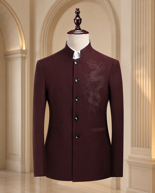 A dark maroon men's jacket with a mandarin collar and subtle dragon embroidery on the chest, displayed on a mannequin in an elegant indoor setting with arched columns.