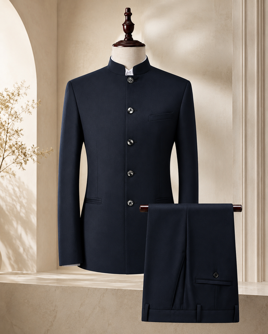 A dark navy blue traditional formal suit set consisting of a mandarin-collar jacket displayed on a mannequin and matching trousers draped over a stand, set against a warm beige architectural background.
