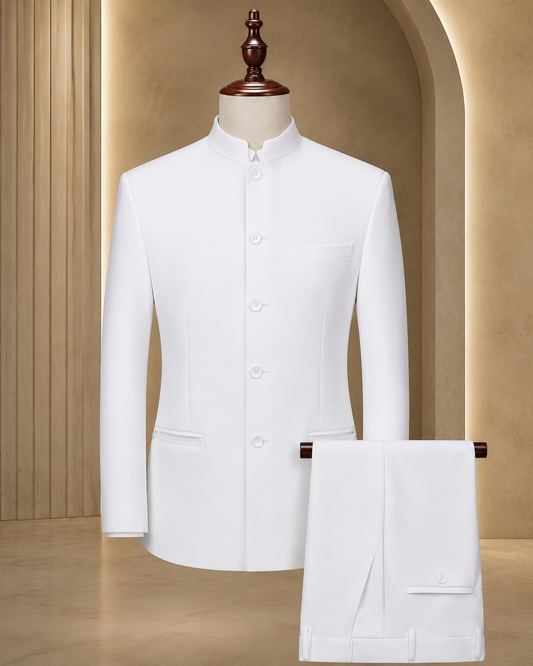 A white men's formal suit set consisting of a mandarin-collar jacket displayed on a mannequin and matching trousers folded over a hanger, set against a warm beige architectural background.